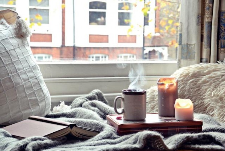 Cozy home. Candles, book and cup of tea